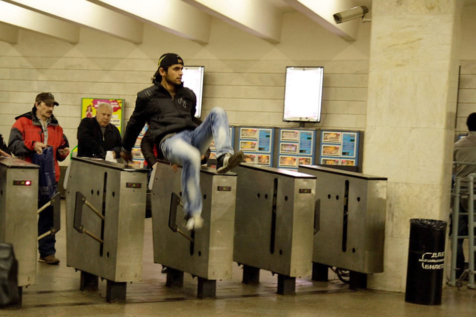 A ‘free-rider’ jumping over subway turnstiles.